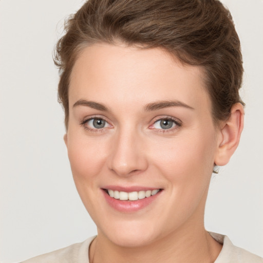 Joyful white young-adult female with short  brown hair and grey eyes