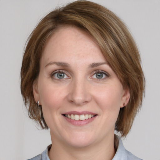 Joyful white young-adult female with medium  brown hair and blue eyes