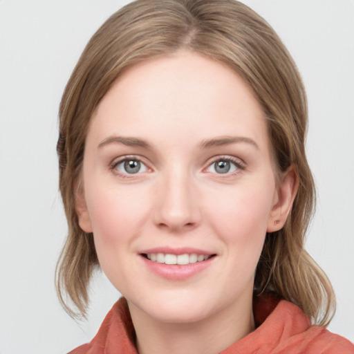 Joyful white young-adult female with medium  brown hair and blue eyes