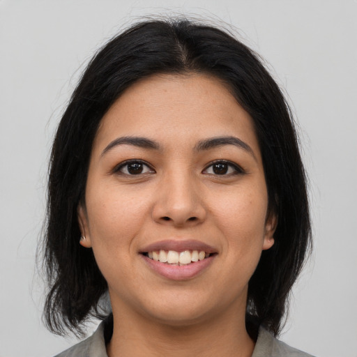 Joyful latino young-adult female with medium  brown hair and brown eyes