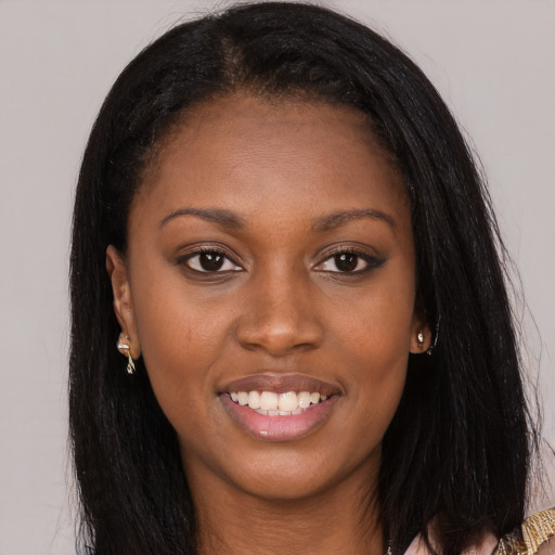 Joyful black young-adult female with long  brown hair and brown eyes
