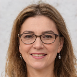 Joyful white adult female with long  brown hair and grey eyes