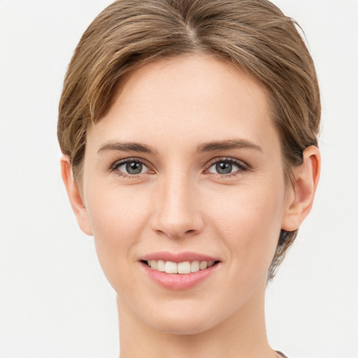 Joyful white young-adult female with medium  brown hair and grey eyes