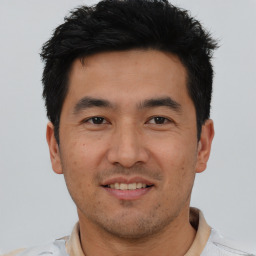 Joyful asian young-adult male with short  black hair and brown eyes