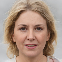 Joyful white adult female with medium  brown hair and blue eyes