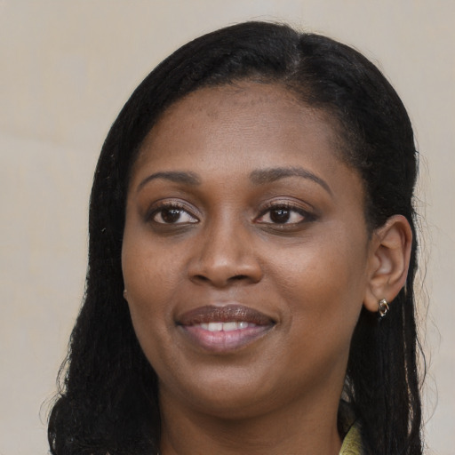 Joyful black young-adult female with long  black hair and brown eyes