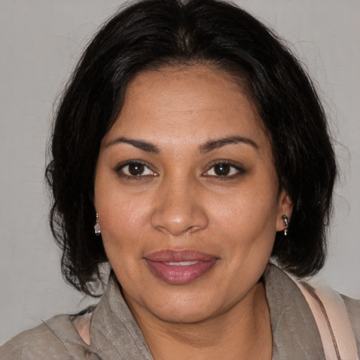 Joyful black adult female with medium  brown hair and brown eyes