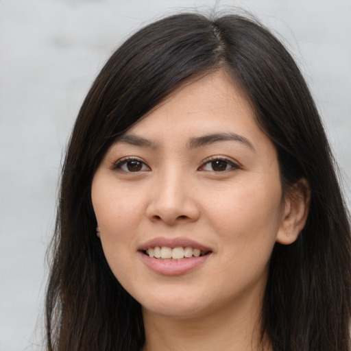 Joyful asian young-adult female with long  brown hair and brown eyes