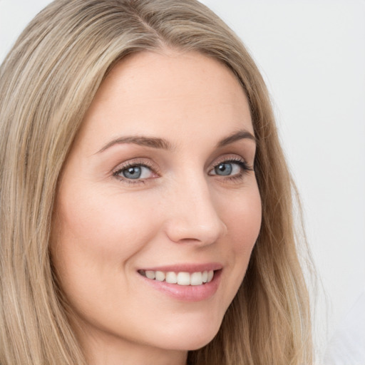 Joyful white young-adult female with long  brown hair and green eyes