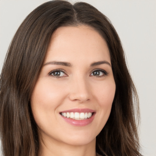 Joyful white young-adult female with long  brown hair and brown eyes