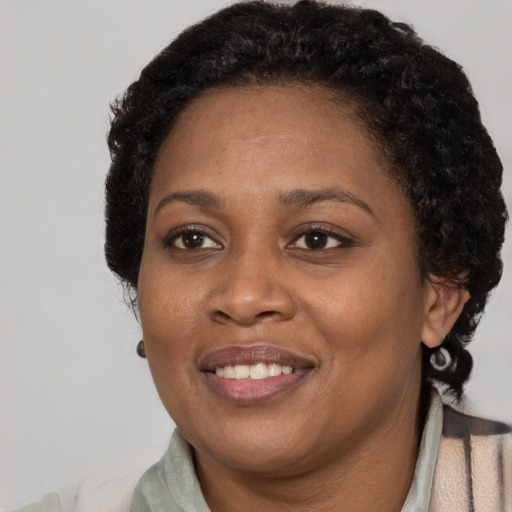 Joyful black adult female with short  brown hair and brown eyes