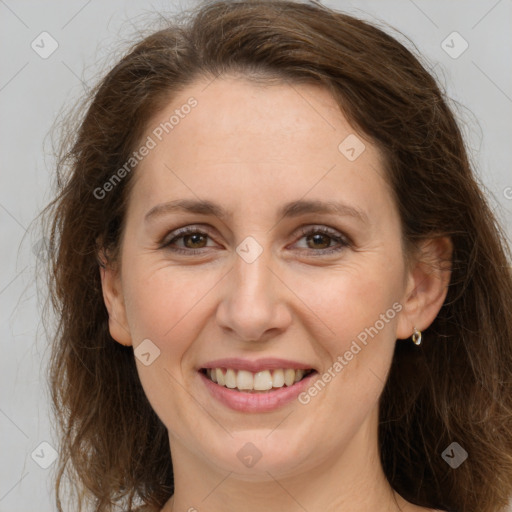 Joyful white adult female with long  brown hair and grey eyes