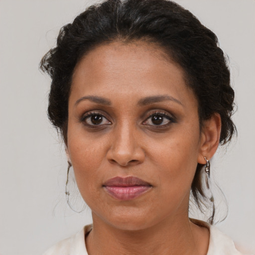 Joyful black adult female with medium  brown hair and brown eyes