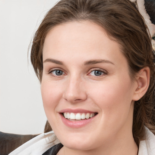 Joyful white young-adult female with medium  brown hair and grey eyes