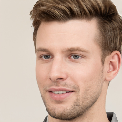 Joyful white young-adult male with short  brown hair and grey eyes