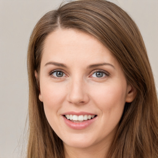 Joyful white young-adult female with long  brown hair and grey eyes