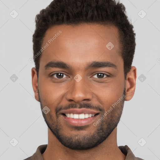 Joyful black young-adult male with short  brown hair and brown eyes