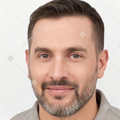 Joyful white adult male with short  brown hair and brown eyes