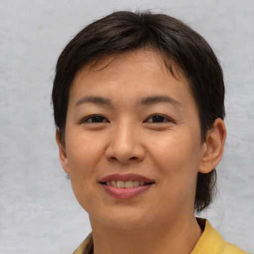Joyful asian young-adult female with short  brown hair and brown eyes