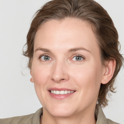 Joyful white adult female with medium  brown hair and grey eyes