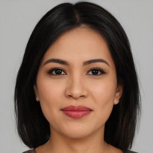 Joyful latino young-adult female with long  black hair and brown eyes