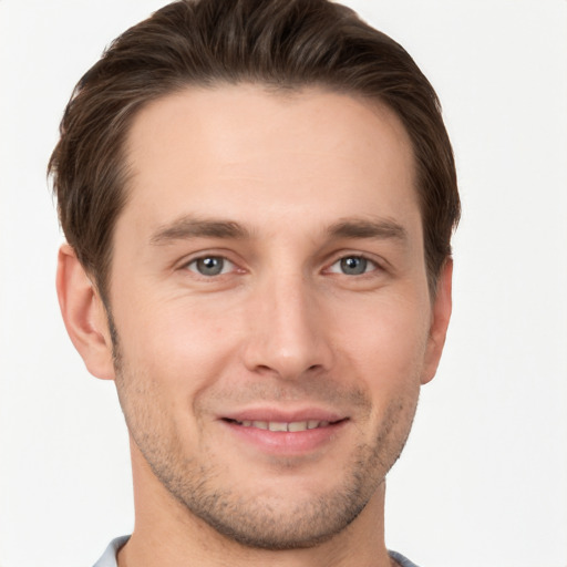 Joyful white young-adult male with short  brown hair and grey eyes