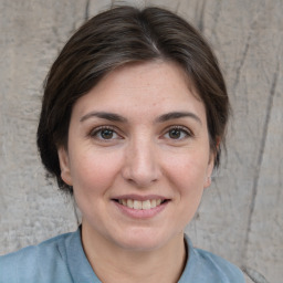 Joyful white young-adult female with medium  brown hair and brown eyes