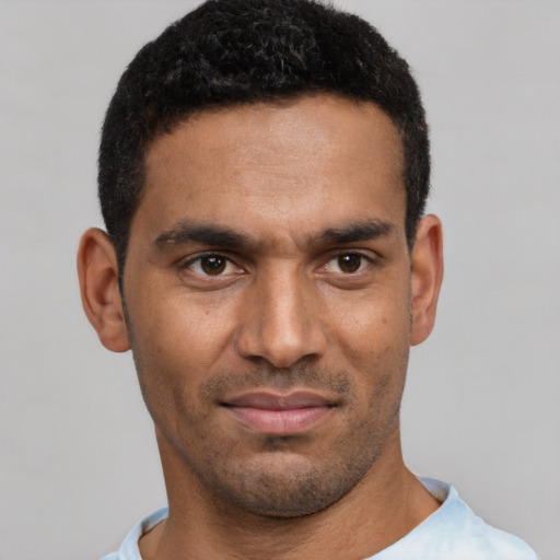 Joyful black young-adult male with short  black hair and brown eyes