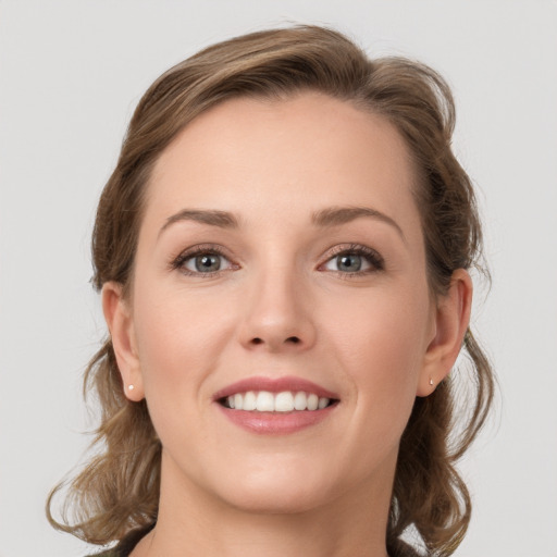 Joyful white young-adult female with medium  brown hair and grey eyes