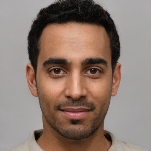 Joyful black young-adult male with short  black hair and brown eyes