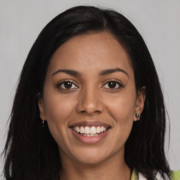 Joyful latino young-adult female with long  brown hair and brown eyes