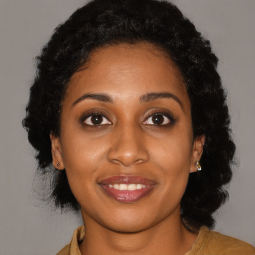 Joyful black young-adult female with long  black hair and brown eyes
