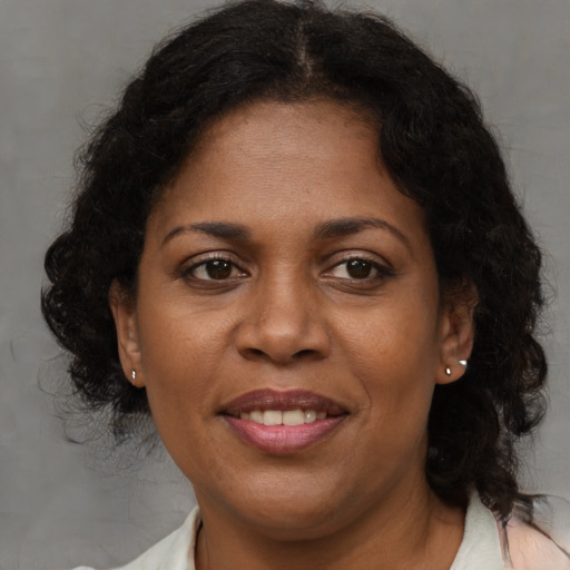Joyful black adult female with medium  brown hair and brown eyes