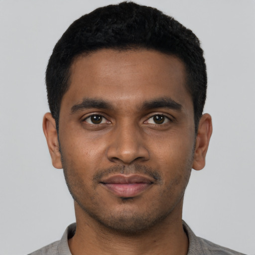 Joyful black young-adult male with short  black hair and brown eyes