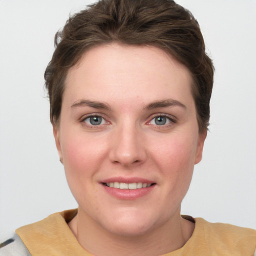 Joyful white young-adult female with short  brown hair and grey eyes