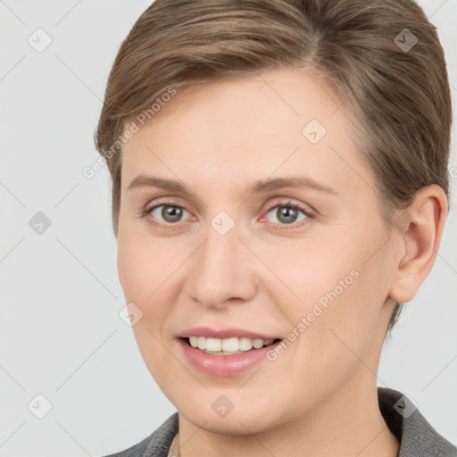 Joyful white young-adult female with medium  brown hair and grey eyes