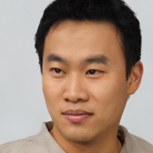 Joyful asian young-adult male with short  black hair and brown eyes