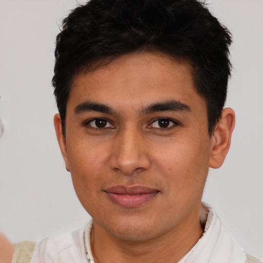 Joyful latino young-adult male with short  brown hair and brown eyes