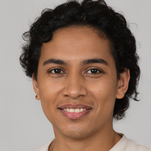 Joyful latino young-adult male with short  brown hair and brown eyes