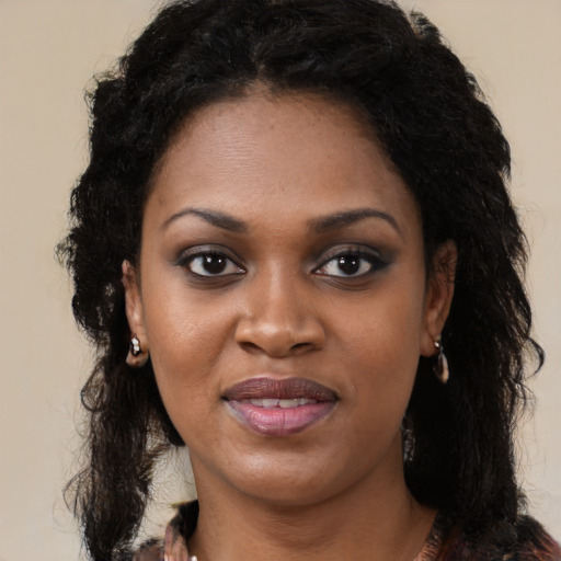 Joyful black young-adult female with long  black hair and brown eyes