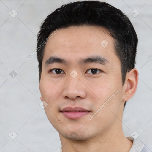 Joyful asian young-adult male with short  black hair and brown eyes