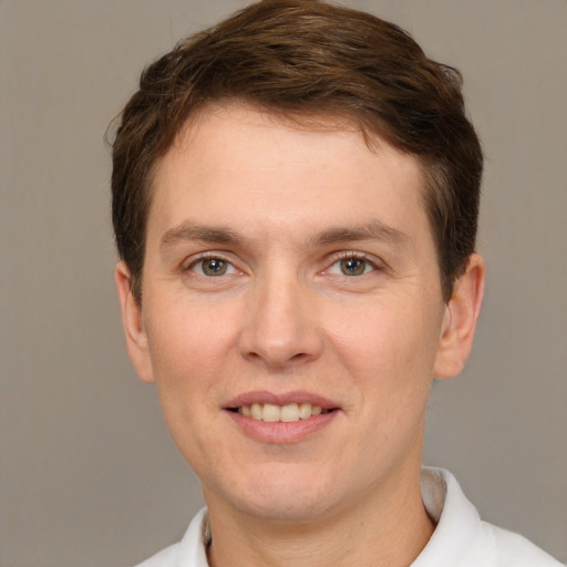 Joyful white adult male with short  brown hair and grey eyes