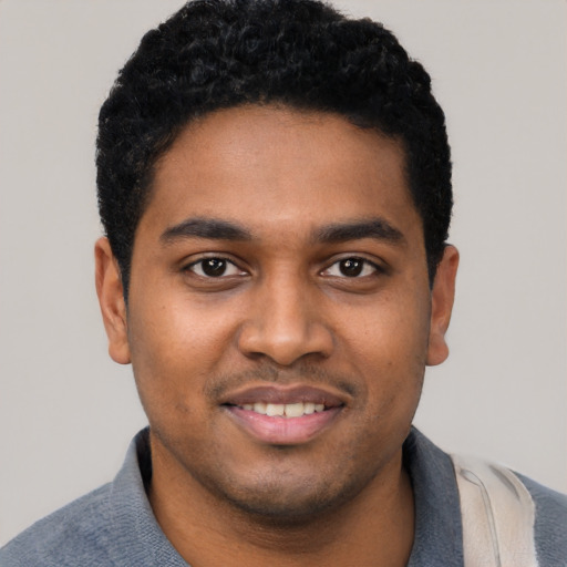 Joyful black young-adult male with short  black hair and brown eyes