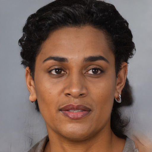 Joyful black adult female with short  brown hair and brown eyes