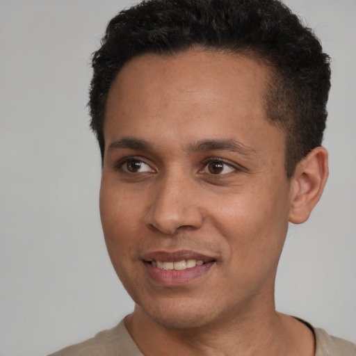 Joyful black young-adult male with short  brown hair and brown eyes