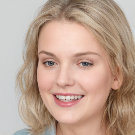 Joyful white young-adult female with long  brown hair and blue eyes