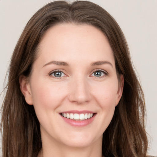 Joyful white young-adult female with long  brown hair and grey eyes