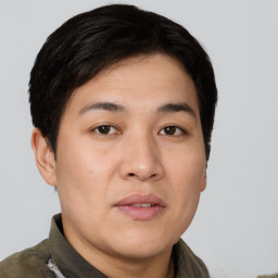 Joyful asian young-adult male with short  brown hair and brown eyes