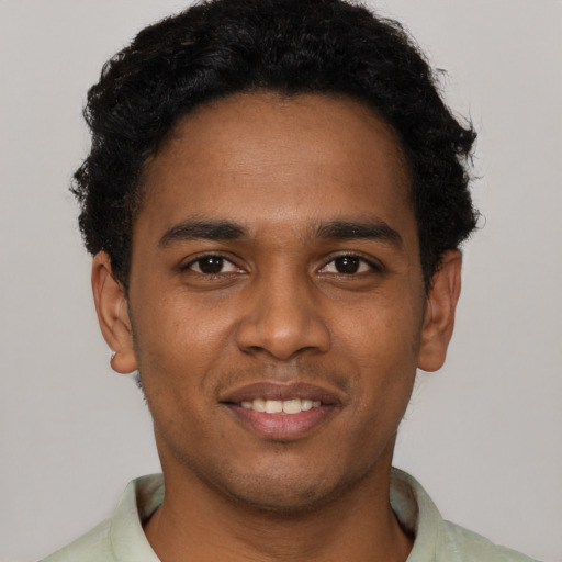Joyful black young-adult male with short  black hair and brown eyes
