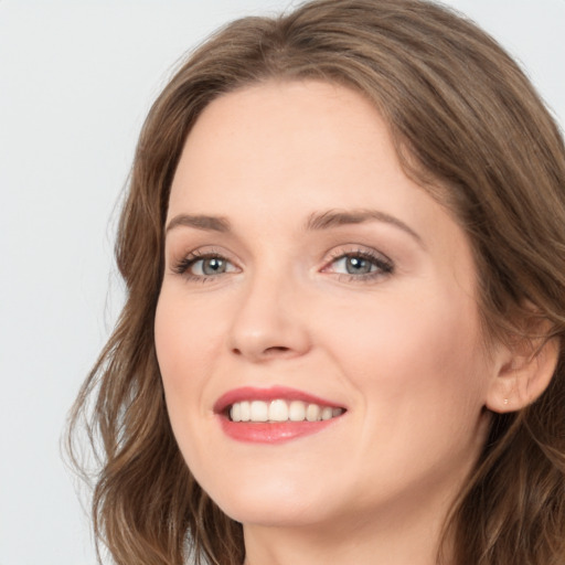 Joyful white young-adult female with long  brown hair and green eyes